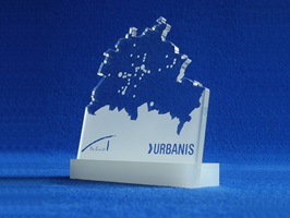 Award aus weiß hinterdrucktem, farblosen Acrylglas. Der Award zeigt im oberen Bereich den Umriss einer Landkarte. Die Platte steckt in einem Halter aus opal-weißen Acrylglas.