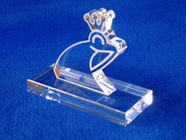 Foto zeigt einen Award aus Acrylglas mit Froschmotiv. Der Frosch ist teilweise lasergraviert. Der Frosch ist auf einer Grundplatte aus massiven, farblosem Acrylglas verklebt.